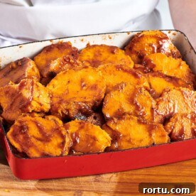 Red baking dish of Candied Sweet Potatoes.