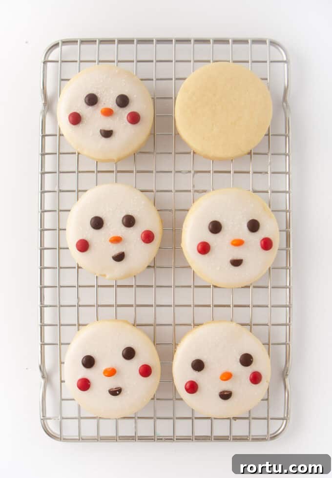 6 decorated snowman cookies on wire cooling rack