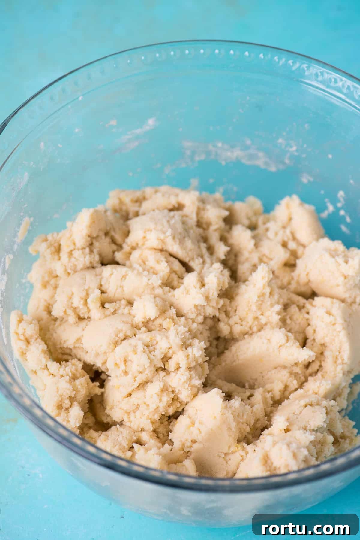 cookie batter in a glass bowl on blue background