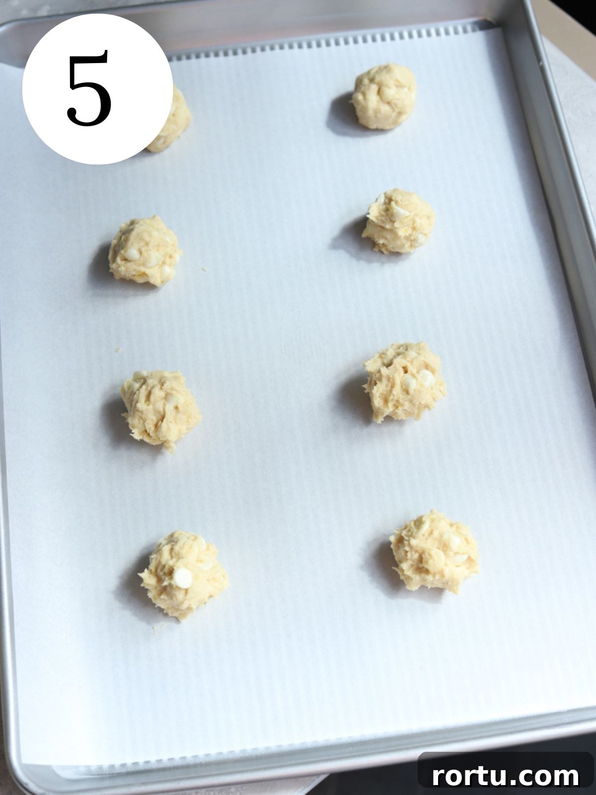 Lemon White Chocolate Cookie Recipe: Zesty Homemade Treat 8 Cookie dough balls on a baking sheet