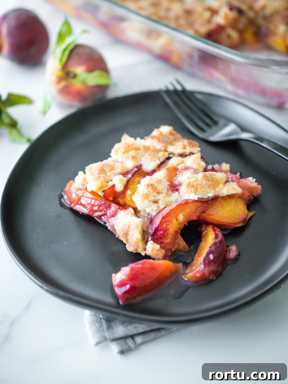 peach cobbler on a black plate