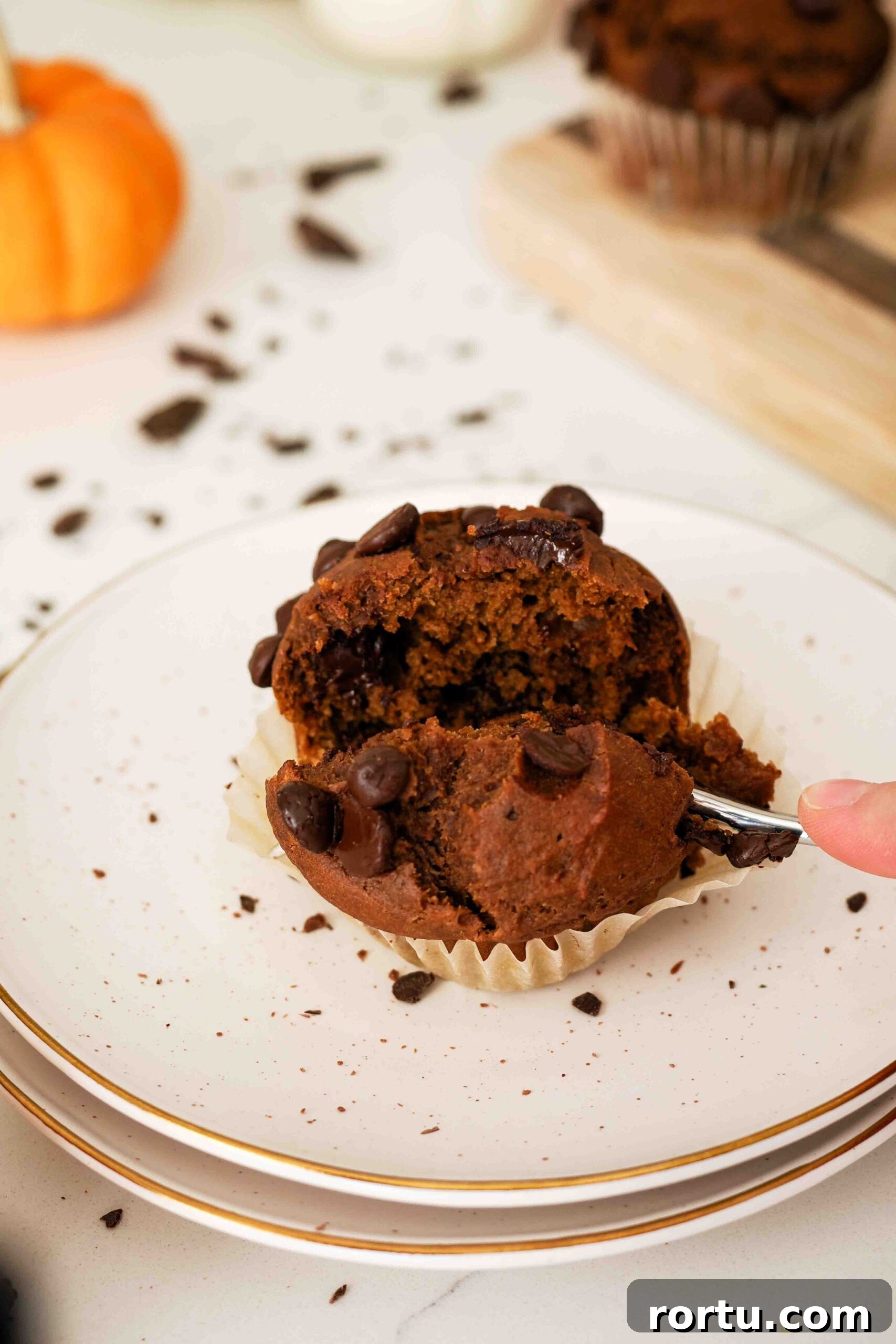 Chocolate Pumpkin Muffins Recipe — Moist Spiced Chocolate Muffins 12 A fork divides a chocolate pumpkin muffin in two.