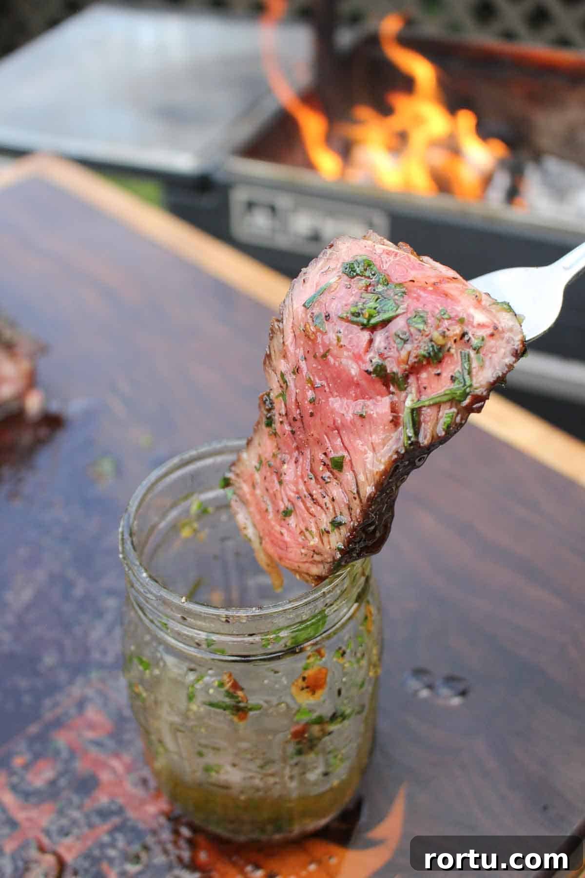 Steak being dipped in the Smoked Steak Butter