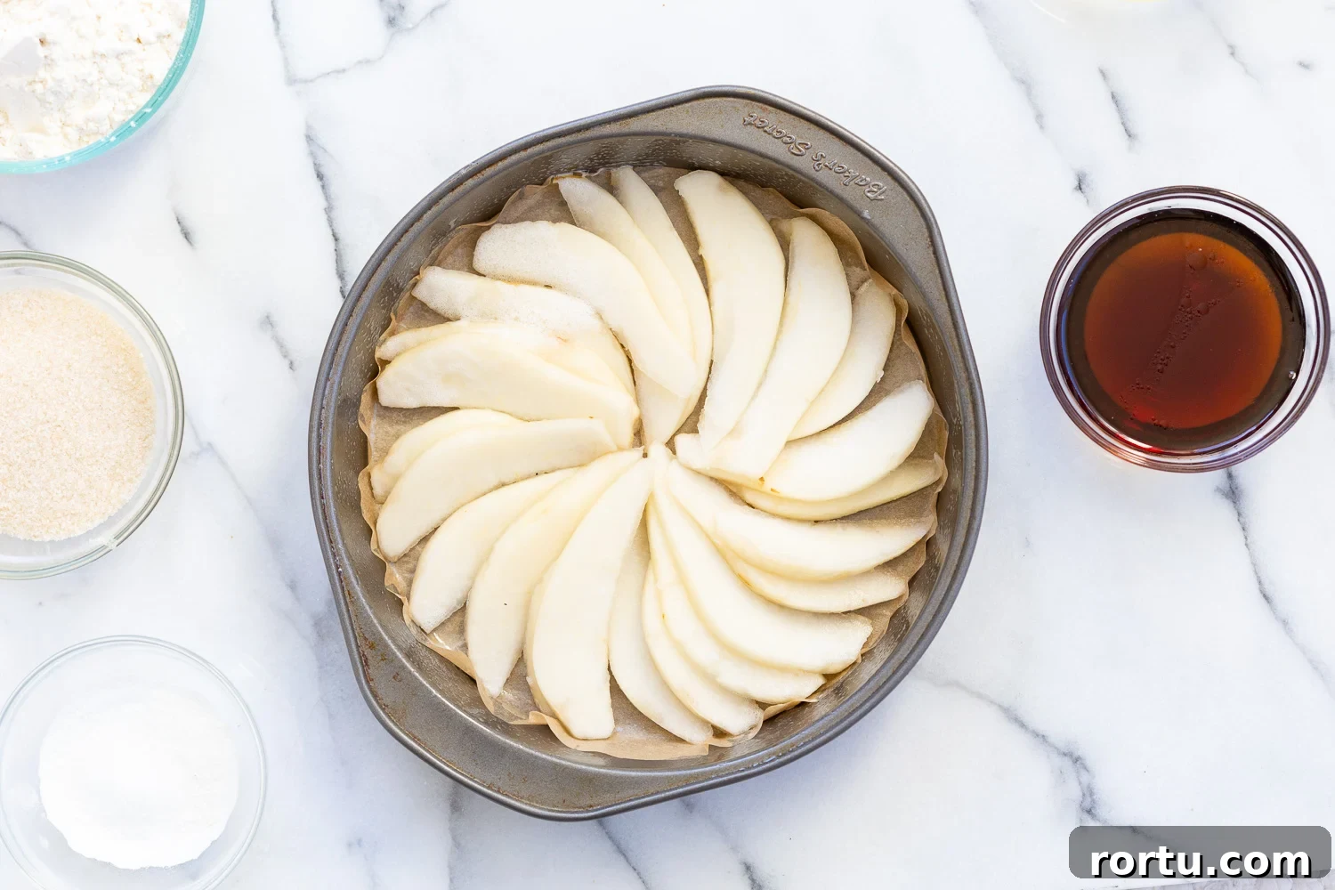 Pears arranged in a cake pan for Our Vegan Pear Upside Down Cake