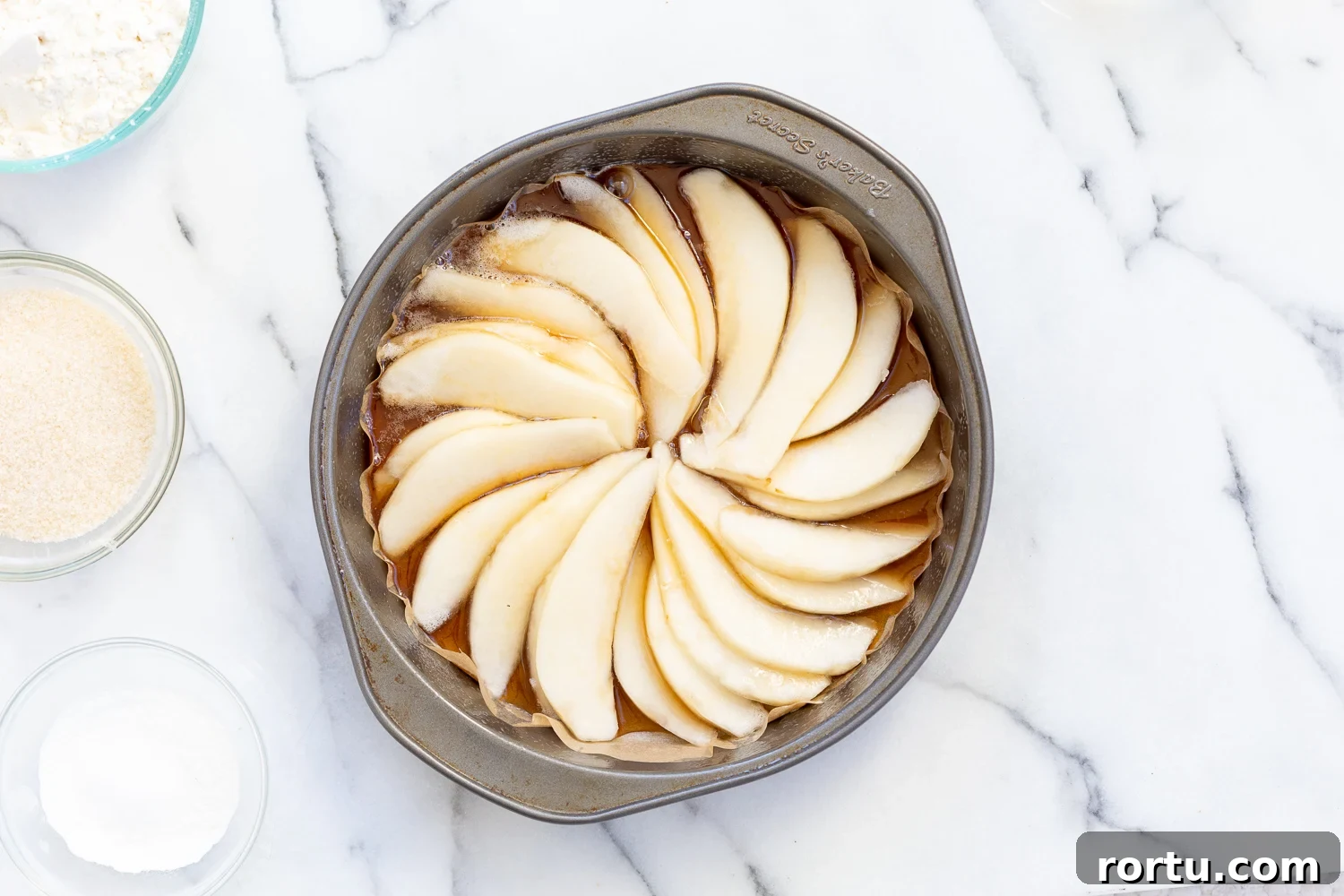 Pears arranged in a cake pan for Our Vegan Pear Upside Down Cake