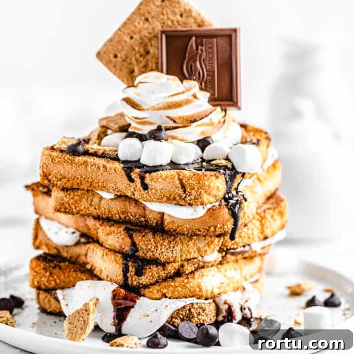 stack of marshmallow filled graham cracker French toast topped with chocolate, marshmallows and graham crackers