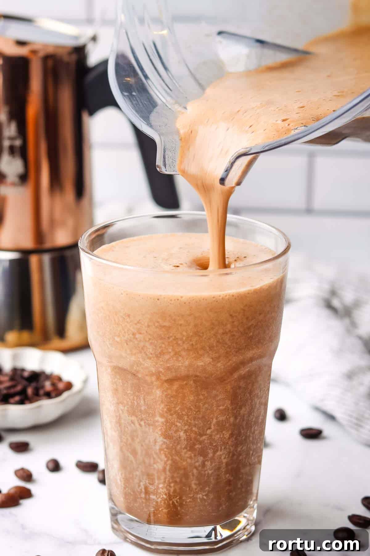 Energizing Banana Coffee Smoothie Recipe for Morning Boost 7 Coffee banana smoothie being poured from a blender into a glass.