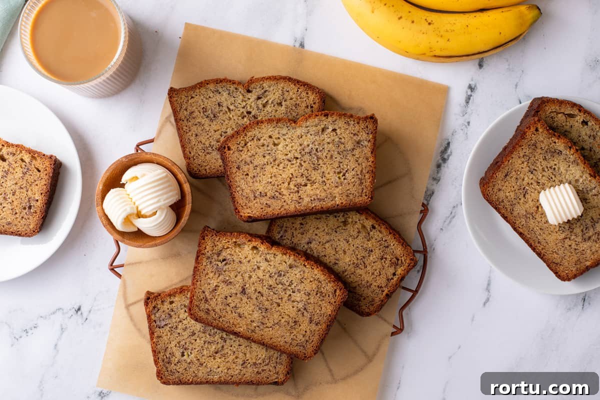Overhead view of slices of dominique ansel's banana bread arranged on a piece of parchment paper.
