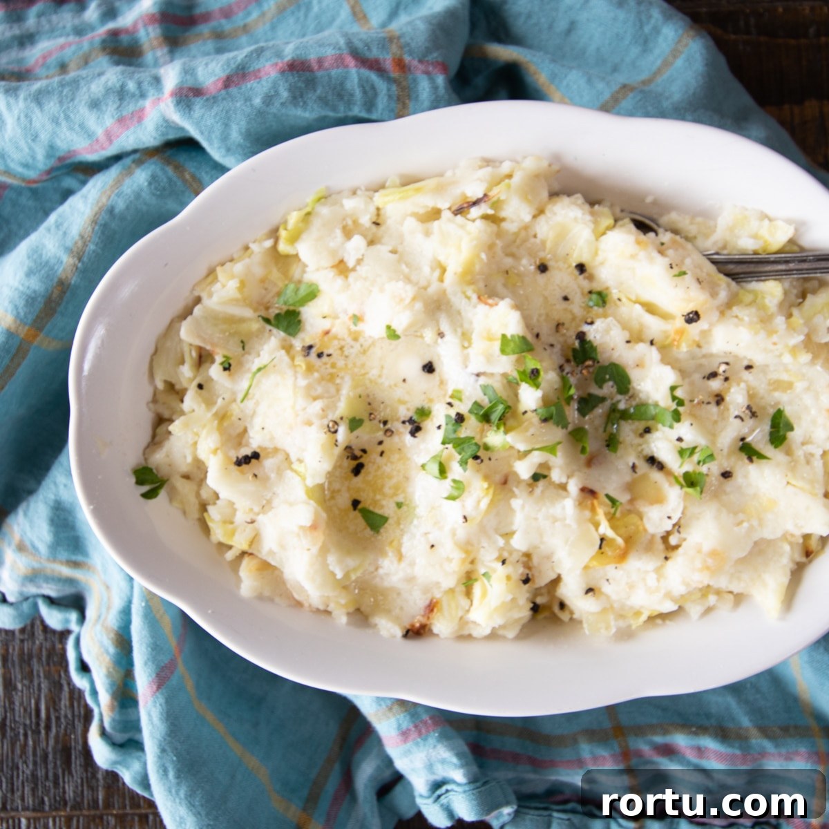 Colcannon Recipe: Traditional Irish Mashed Potatoes with Cabbage 2 A bowl of colcannon Irish mashed potatoes topped with melted butter, parsley and coarse black pepper.