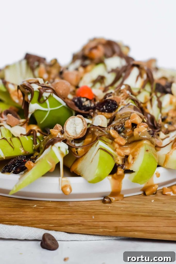 Apple Cinnamon Bites Recipe: Quick No-Bake Snack for Kids and Adults 12 close up view of apple nachos toppings on a wooden cutting board.