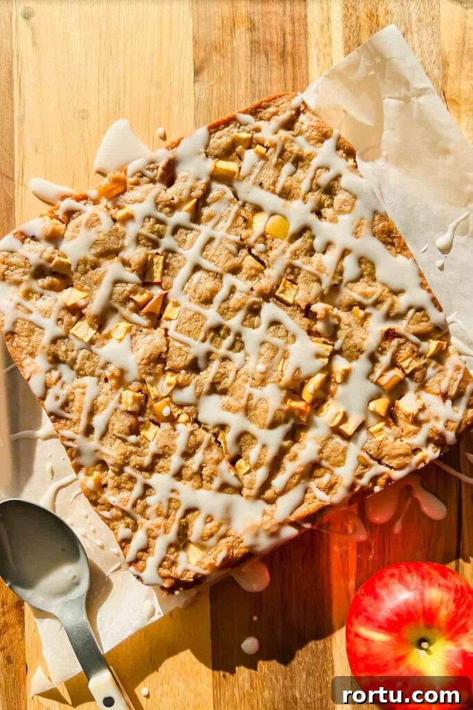 Apple Cinnamon Bites Recipe: Quick No-Bake Snack for Kids and Adults 9 apple cinnamon blondies drizzled with icing on parchment paper.