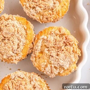 Four Apple Cinnamon Streusel Muffins on a white platter.