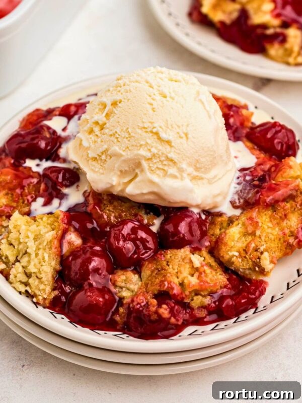 Creamy Mint Grasshopper Pie Recipe That Impresses 13 Golden crusted cherry dump cake on white plates topped with vanilla ice cream.