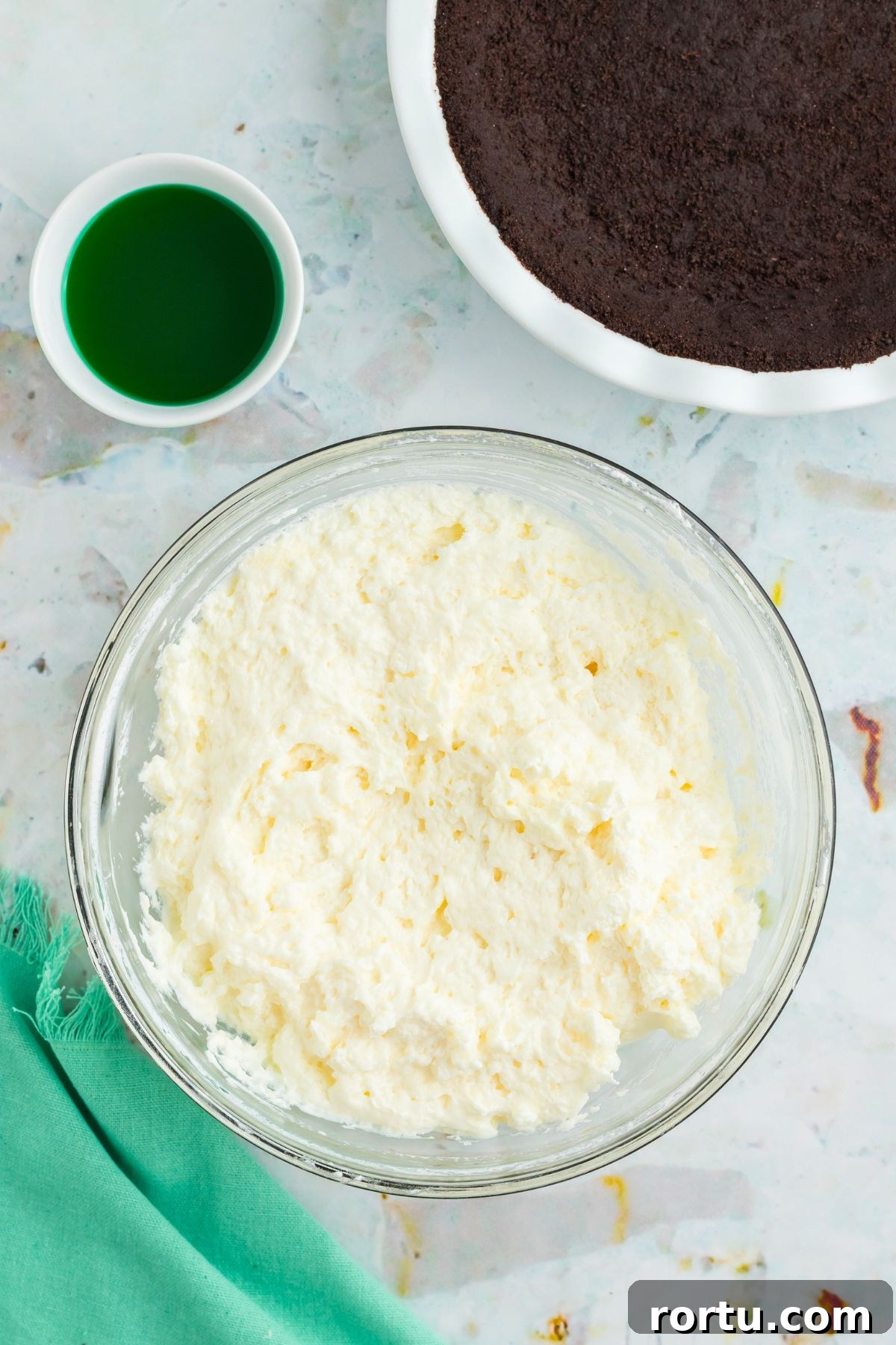 Creamy Mint Grasshopper Pie Recipe That Impresses 7 Heavy cream whipped into a stiff cream in a clear glass bowl.