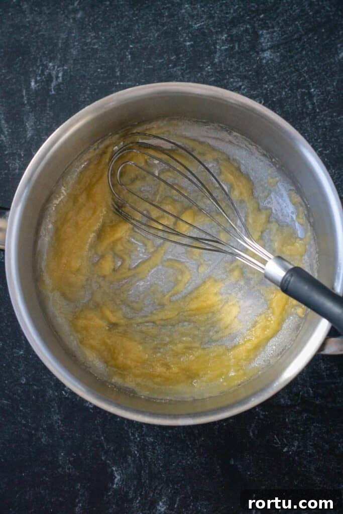 Roux in a pot with a whisk.