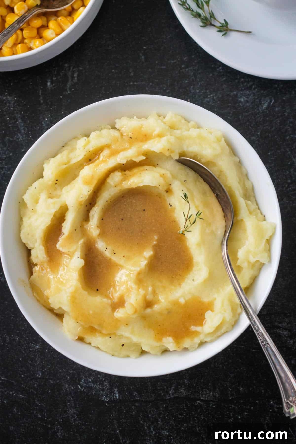 Bowl of mashed potatoes topped with vegan gravy.