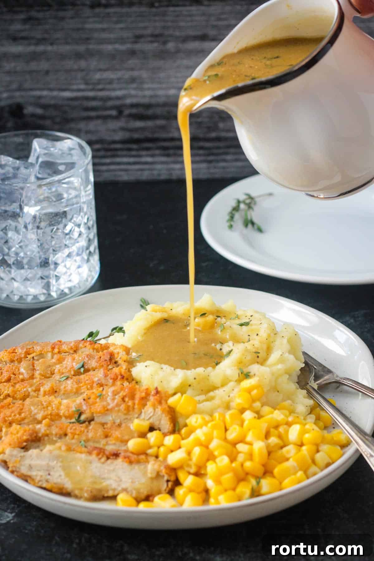 Gravy being poured over a scoop of mashed potatoes.