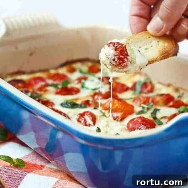Piece of bread dipping into melted cheese and warm tomatoes.