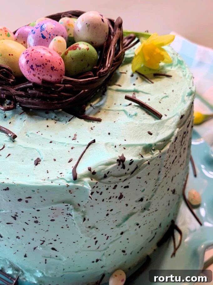 Speckled Easter Cake Recipe: Festive Marbled Holiday Cake 7 A speckled Easter cake with a chocolate nest on top full of candy eggs.