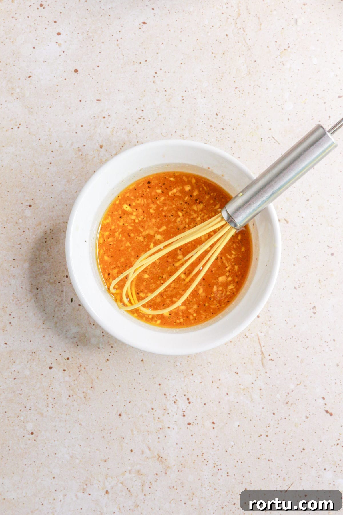 Lime vinaigrette being whisked in a small bowl