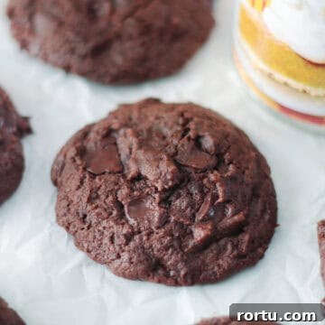 Chocolate pumpkin cookies on parchment paper next to can of pumpkin puree.