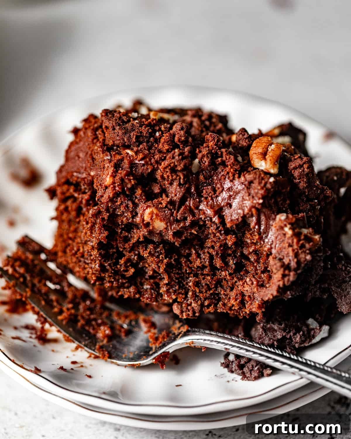 texas sheet cake on a cake plate with a fork. 