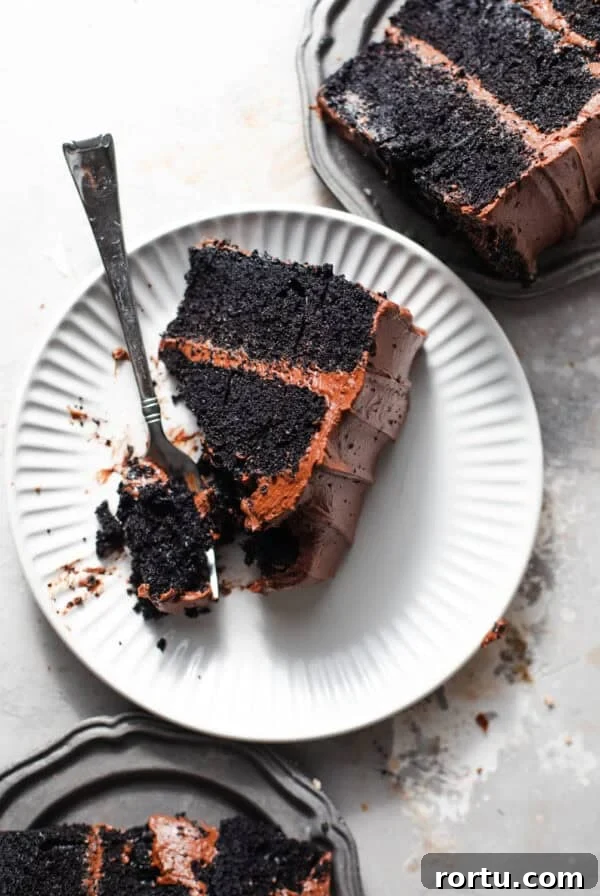 sliced chocolate cake on small plates with forks.