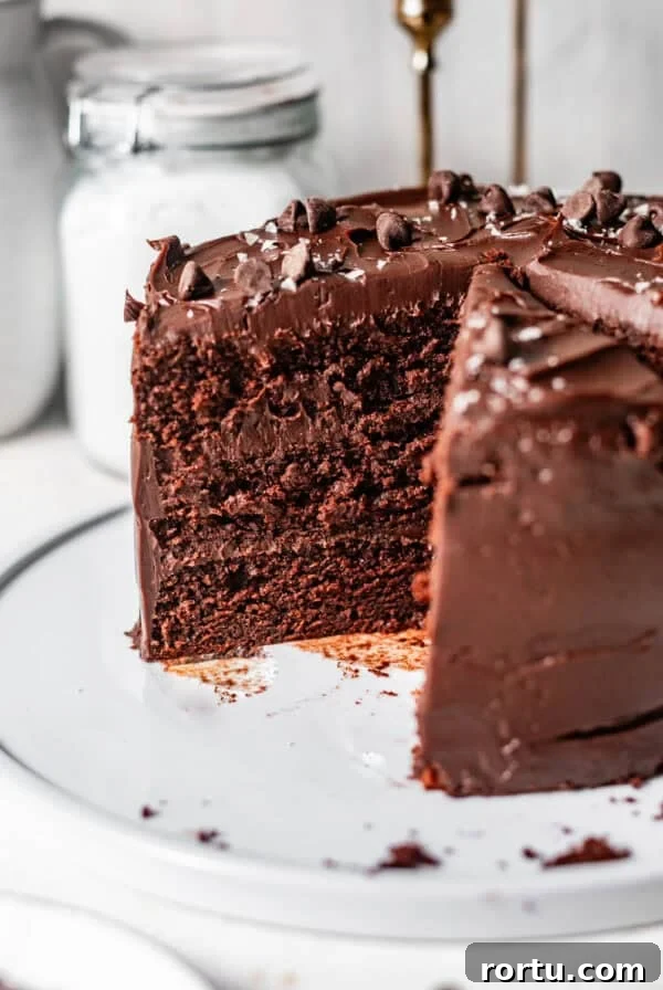 chocolate ganache cake sliced on a cake plate to see the interior of the cake.