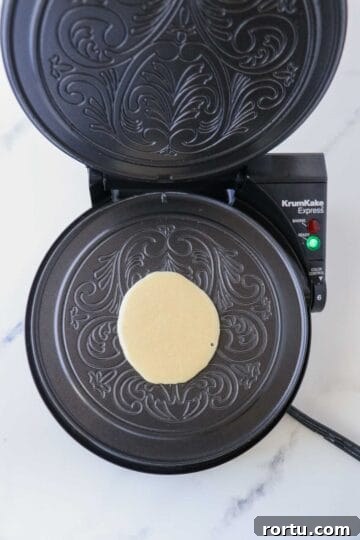 Krumkake batter on a krumkake iron.