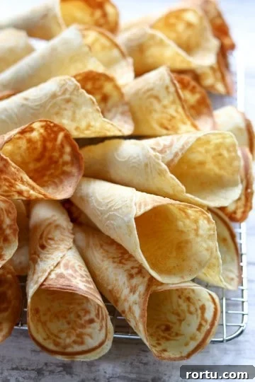 Krumkaker piled onto a wire cooling rack.