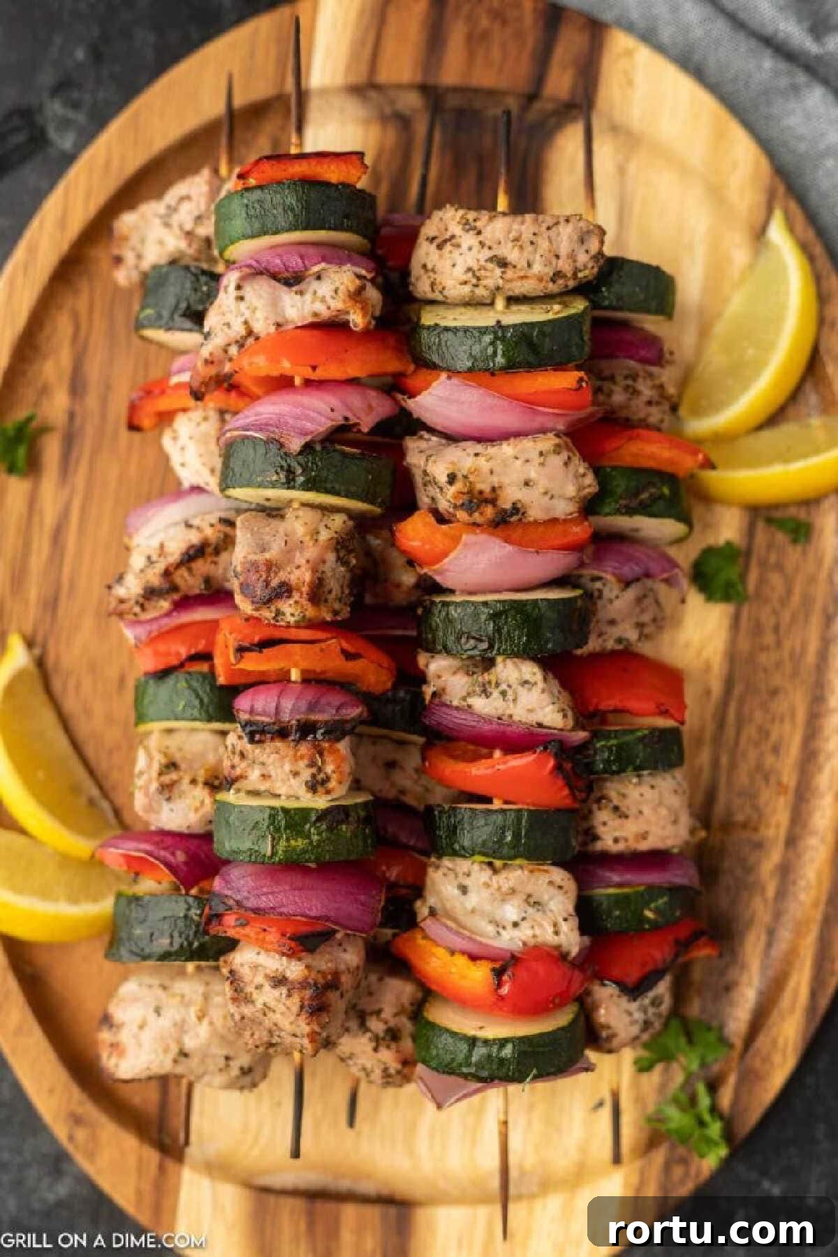 Grilled Pork Kabobs with zucchini, red bell peppers, and red onions on a platter.
