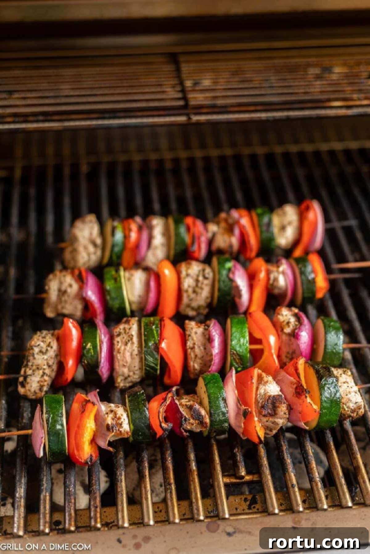 Grilled pork kabobs on the grill grates.