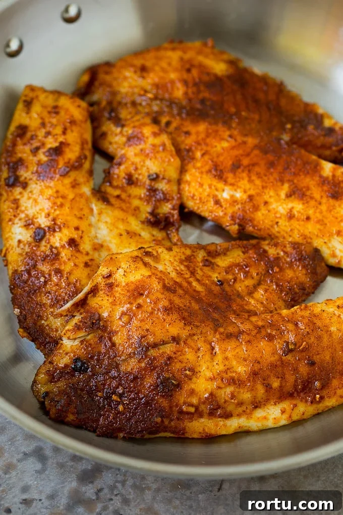 Tilapia fillets in skillet Tilapia fillets coated in taco seasoning and cooked in a skillet.
