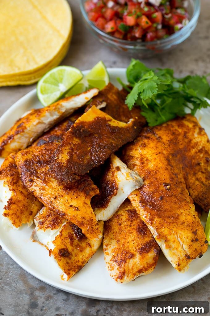 Seasoned fish fillets A plate of taco seasoned fish fillets with a lime and cilantro garnish.