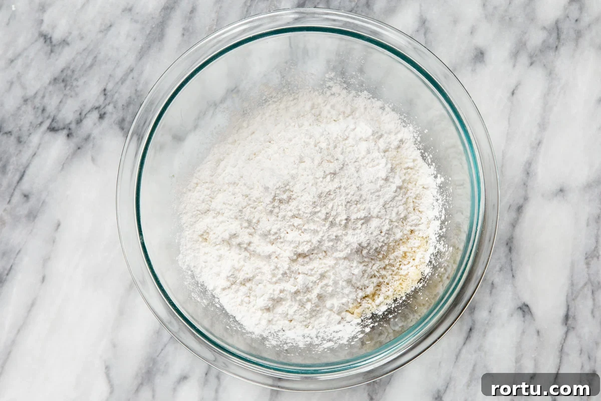 Gluten-Free Vegan Almond Joy Cookies Recipe 8 dry ingredients for making vegan almond joy cookies in a glass bowl