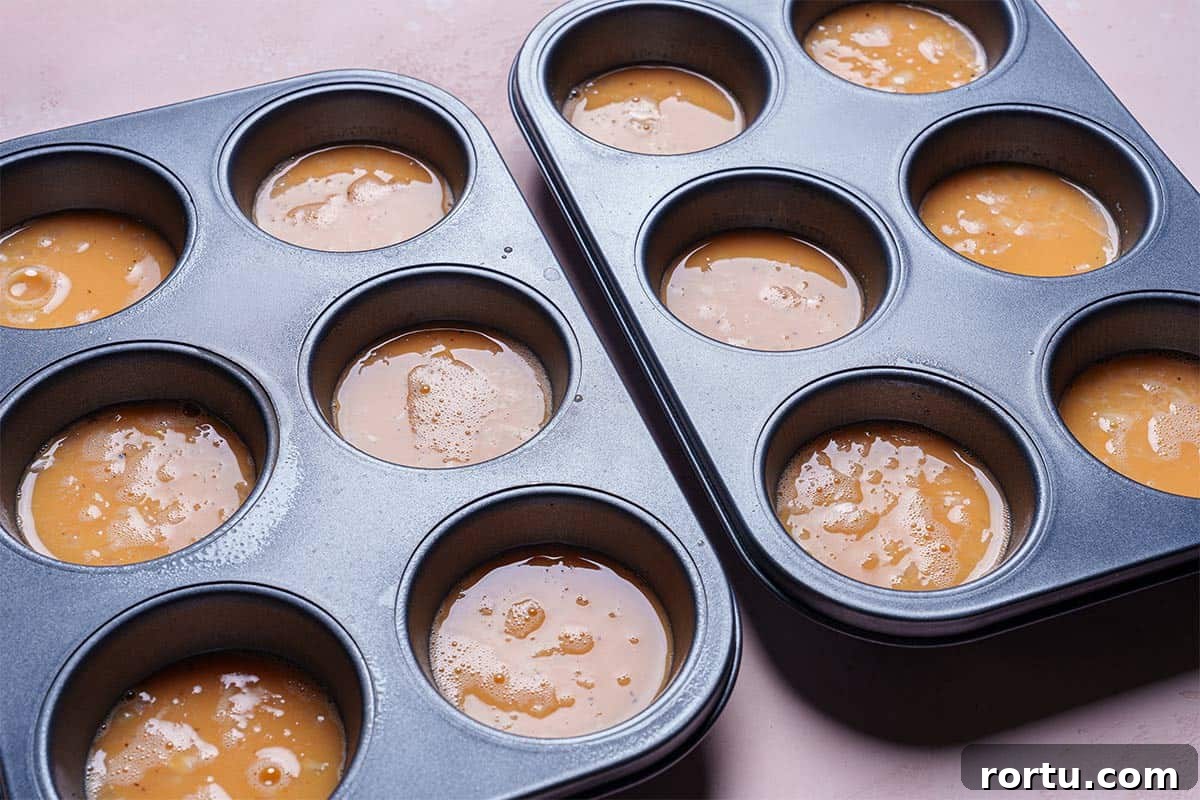 Image of muffin tins filled halfway with egg mixture.