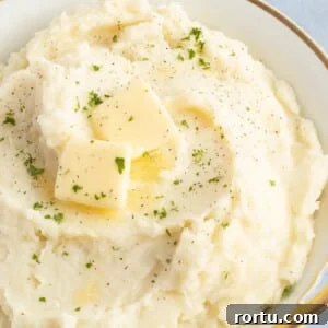Cottage cheese mashed potatoes in a large bowl topped with butter.