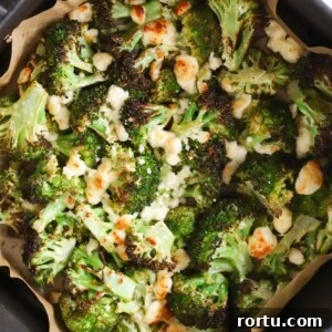 Air fryer broccoli and feta cheese in an air fryer basket.