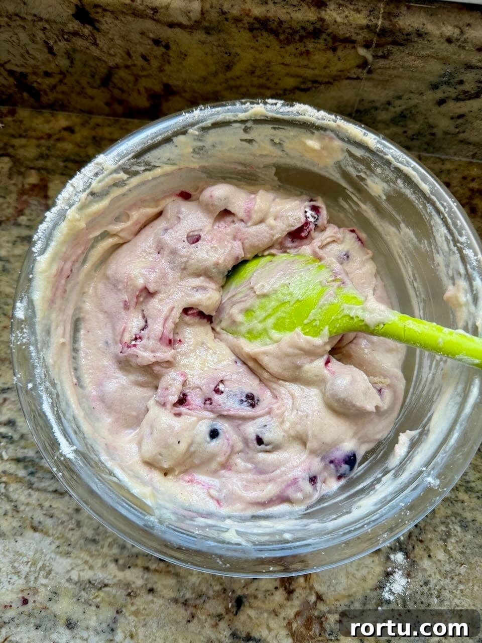 Thick sourdough berry cake batter with mixed berries folded in.