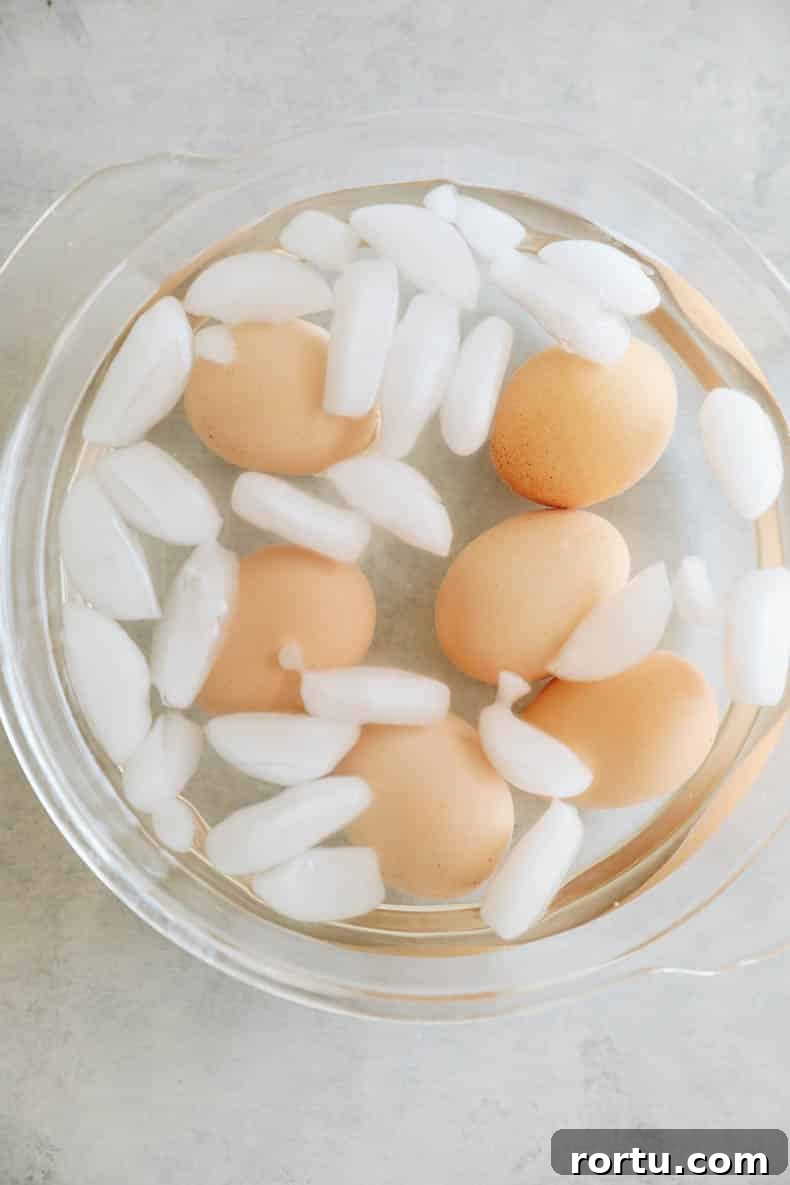 Creamy Avocado Egg Salad Recipe for Quick Lunch or Brunch 3 hard boiled eggs cooling in an egg bath.