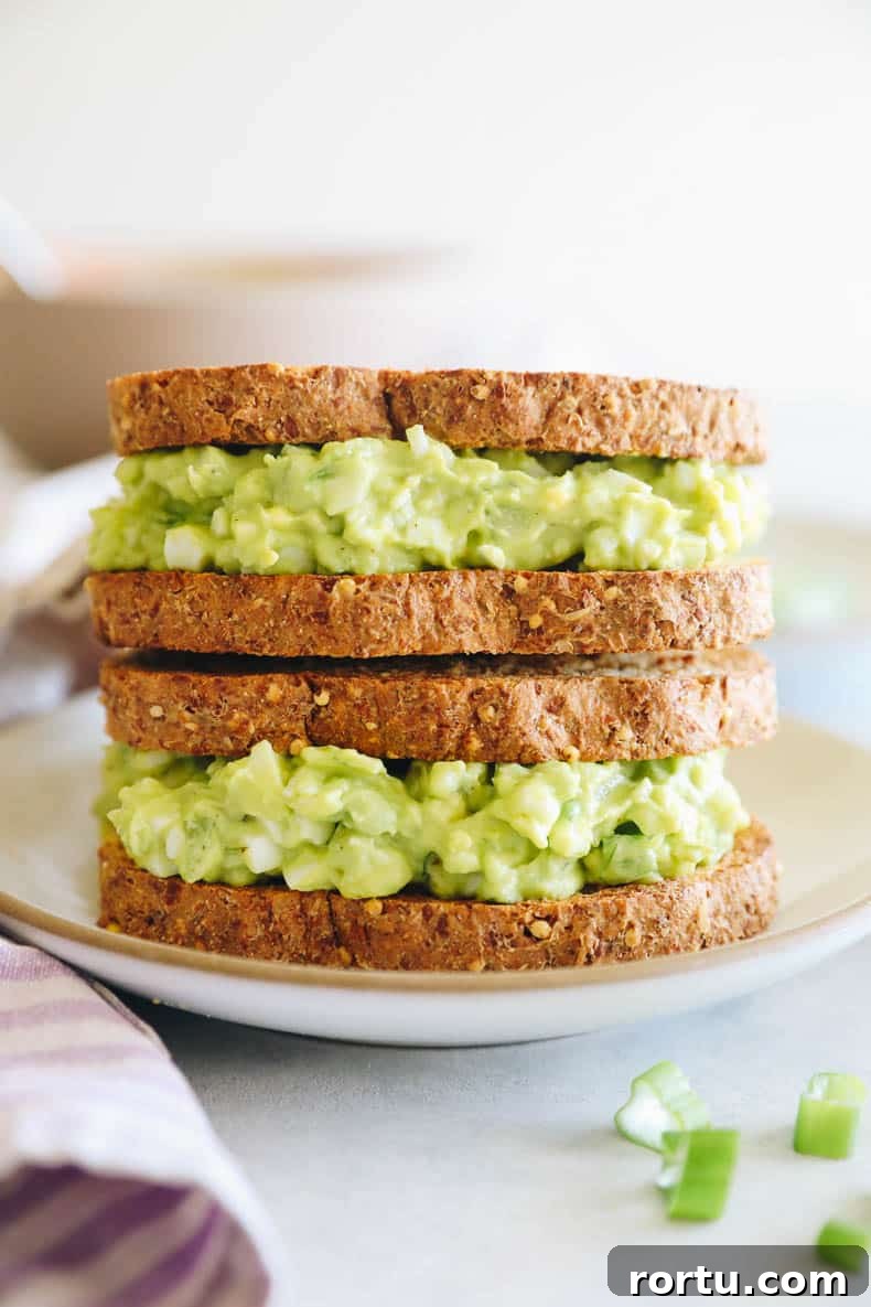 Creamy Avocado Egg Salad Recipe for Quick Lunch or Brunch 8 two avocado egg salad sandwiches stacked on top of each other.