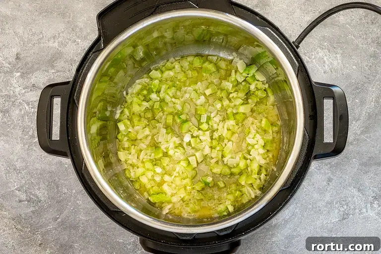 Chopped celery sautéing in an Instant Pot.
