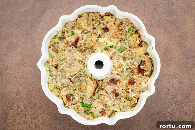 Creamy tuna casserole with chopped vegetables in a white baking dish.