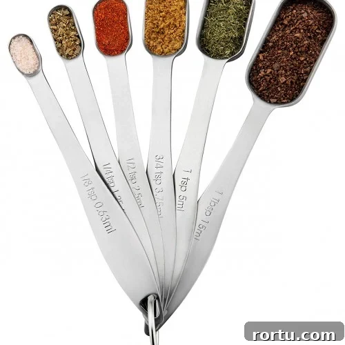 A set of metal measuring spoons fanned out and connected by a ring.