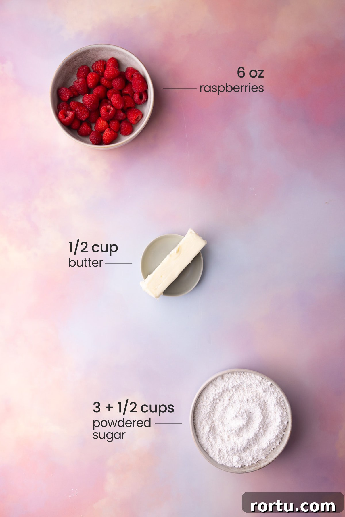 Overhead view of all the ingredients needed for raspberry buttercream - raspberries, butter, and powdered sugar.