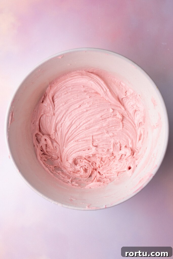 Pink buttercream in a mixing bowl made from fresh raspberries.