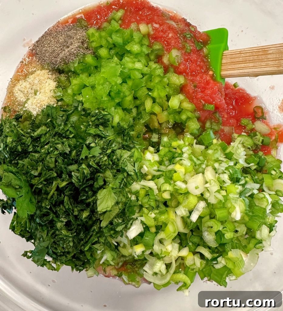Ingredients for salsa in the bowl with the tomato mixture.