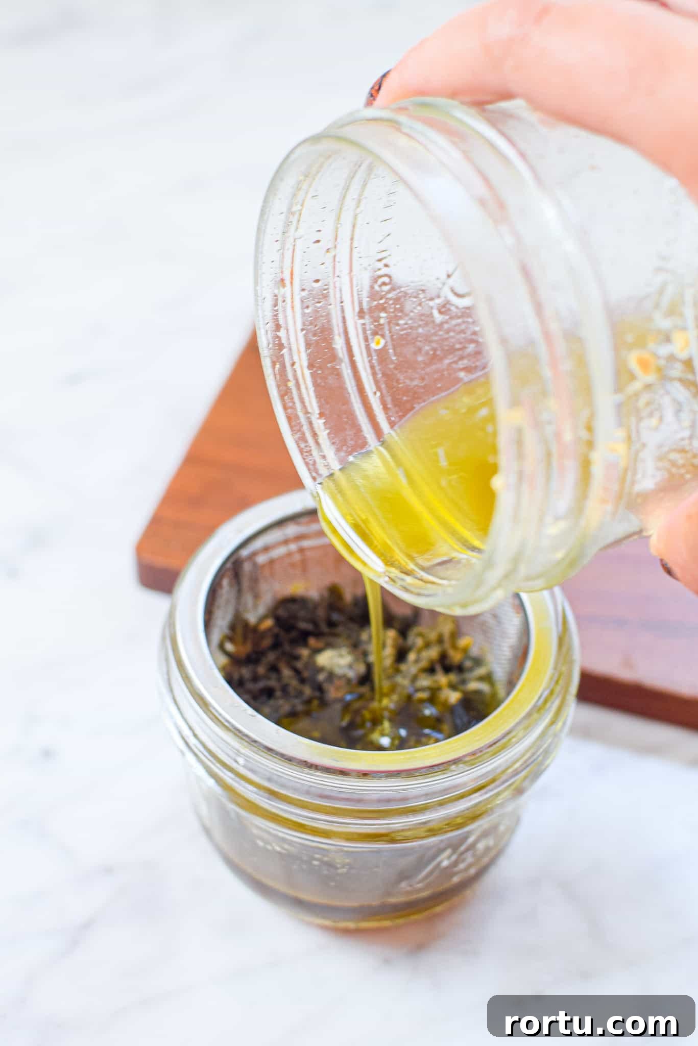 A picture of cannabutter being poured into a mason jar. 