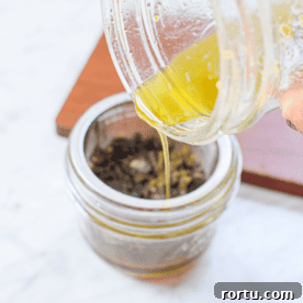 A picture of cannabutter being poured into a mason jar.