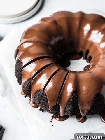 Close up of sliced bundt cake on a white marble background